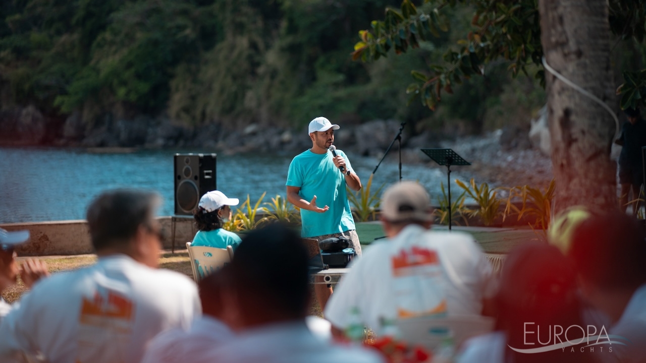 Europa Yachts Marketing Manager Rich Sarinas speaking passionately at a beach party, surrounded by a crowd of people enjoying the sunny day at the Lagoon World Escapade Philippines.